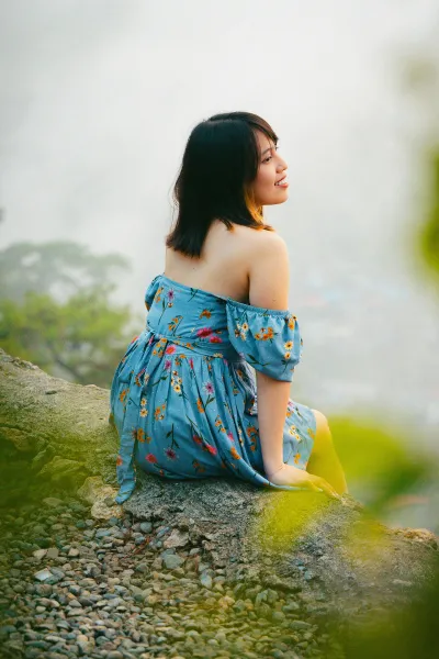 Une belle femme assise sur un tronc d'arbre