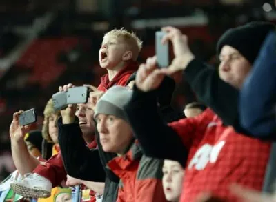 Supporters filmant un match de football