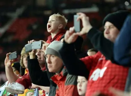 Supporters filmant un match de football image libre de droit